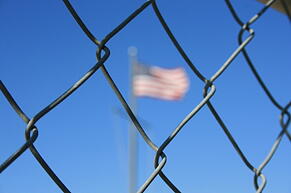 American flag through a fence