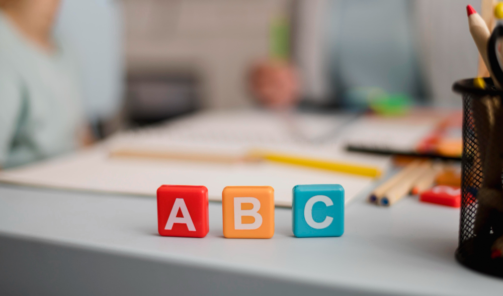 front-view-letters-cubes-with-defocused-tutoring-session-back