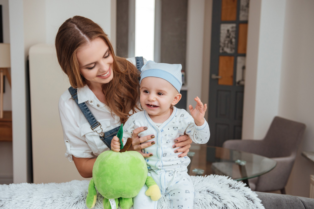 happy-young-mother-holding-playing-with-her-little-son-with-toy-home